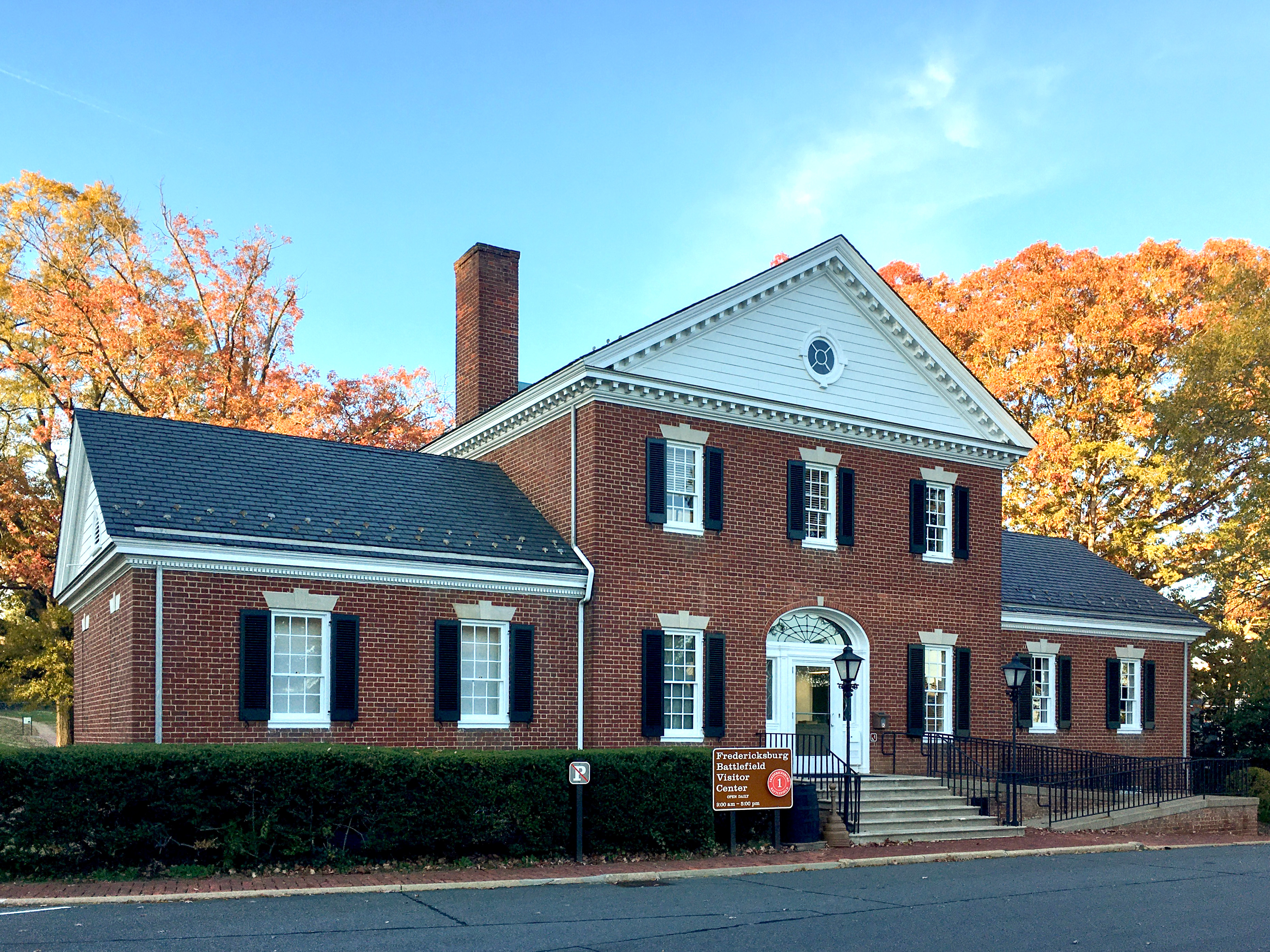 A two story brick building with stairs and ramp entrance.