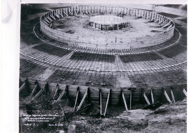 Ring shaped wood forms for the first concrete pour on the base of the memorial. Rebar lies in the bottom of the ring. Labeled: George Rogers Clark Memorial. W.R. Heath Construction Co General Contractors Print No 1 Date 10-10-31