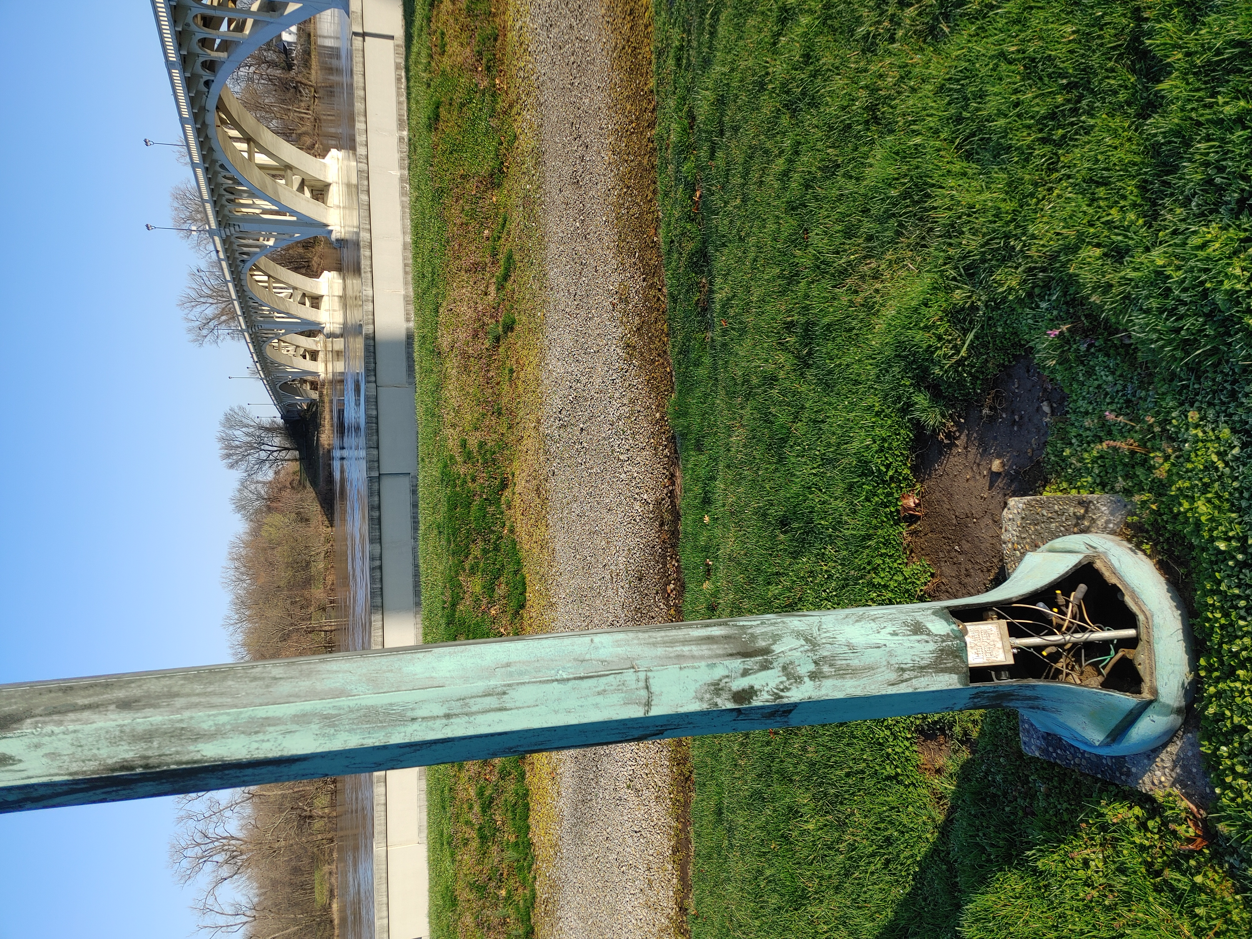 Bronze lampost missing its cover with the Wabash River and Memorial Bridge in background