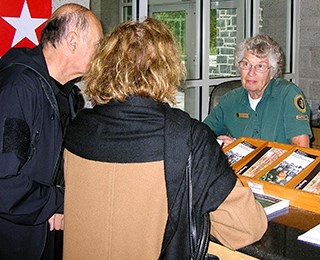 A park volunteer answers visitor questions at the information desk.