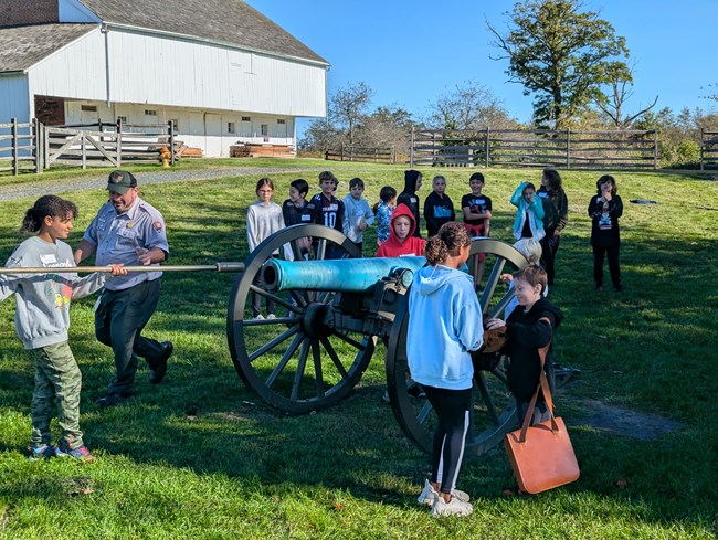 Ranger leads students in the loading of a civil war cannon