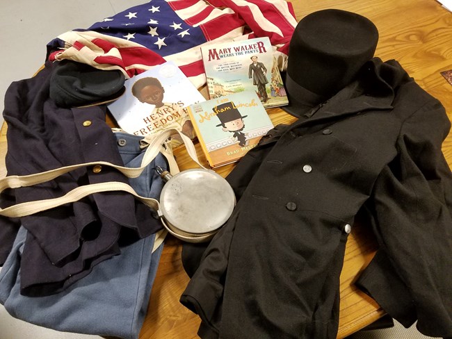 Various items from a Traveling Trunk, including soldier uniform items and books pertaining to the Civil War