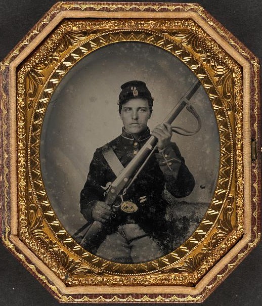 Photograph of a seated US Civil War Soldier holding a musket