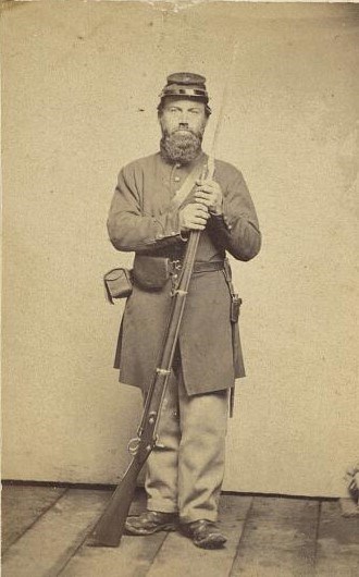 Photograph of an unidentified US Civil War Soldier standing and holding a musket