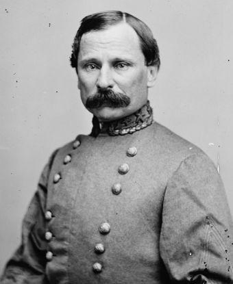Black and white photograph of a man with a black moustache wearing a gray military coat
