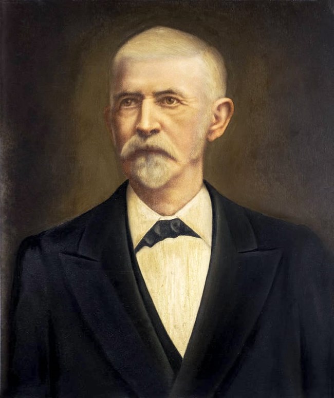 Painted portrait of a man with white hair and a beard wearing a black suite