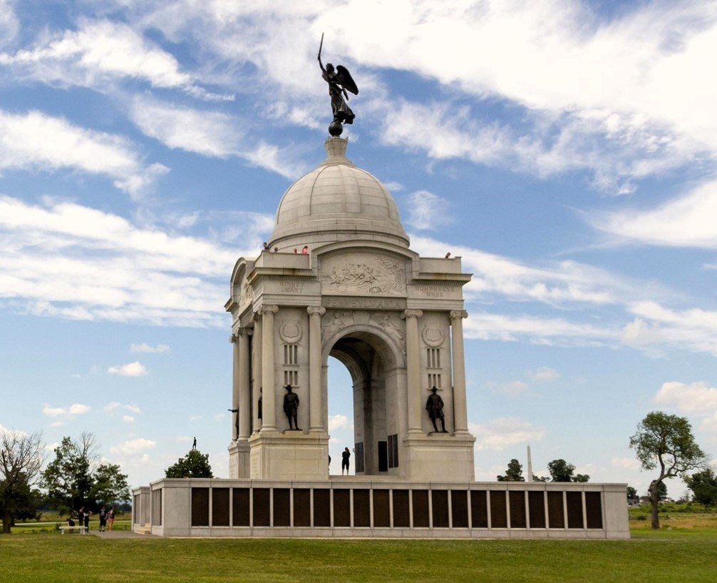 Photograph of the large domed Pennsylvania Monument with blue skies in the background; a bronze statue of the Winged Angel of Victory stands atop the monument.