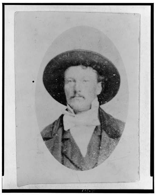 balck and white phototgraph of a man wearing a large brimmed hat and light colored bowtie