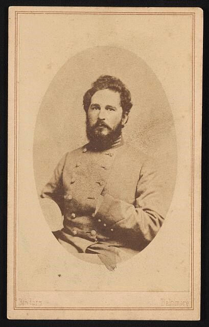 Balck and white photo of a bearded man wearing a gray coat