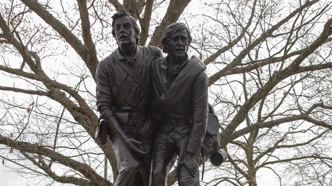 A portion of a bronze monument of two soldiers