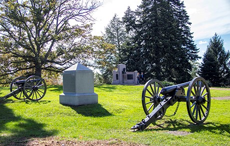 Two cannons flank the white granite obelisk monument to the 1st Massachusetts Battery.