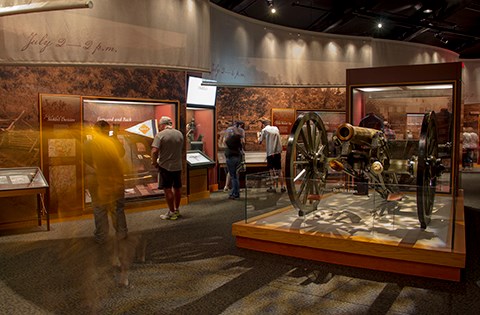 Visitors move around inside the cannon gallery inside the park museum.
