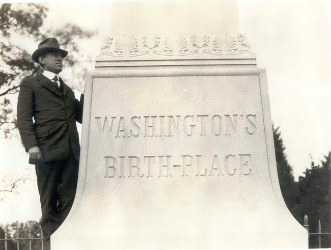 sepia toned image of a man standing next to the monument