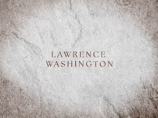 A stone slab with text engraved reads "Lawrence Washington"