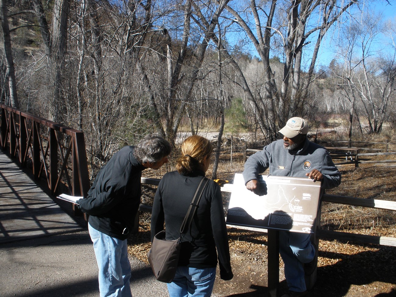 A volunteer ranger orients visitors to the trail conditions at Cliff Dweller Canyon trailhead.