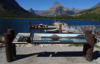 Panoramic wayside and bronze tactile by boat dock on mountain lakeshore