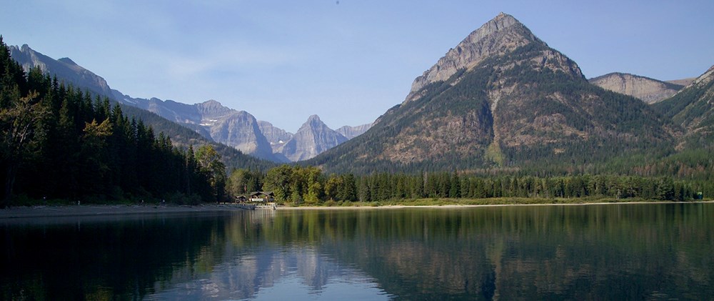 ranger station on lakeshore surrounded by peaks