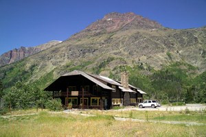 Sitting in front of a mountain is a large wood building with eave overhanging porch