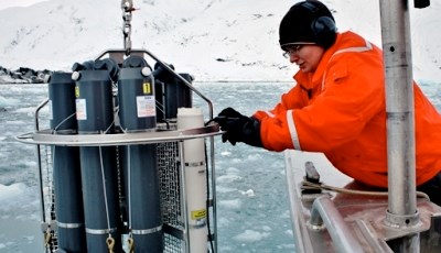 Researcher lowering scientific instruments into ocean
