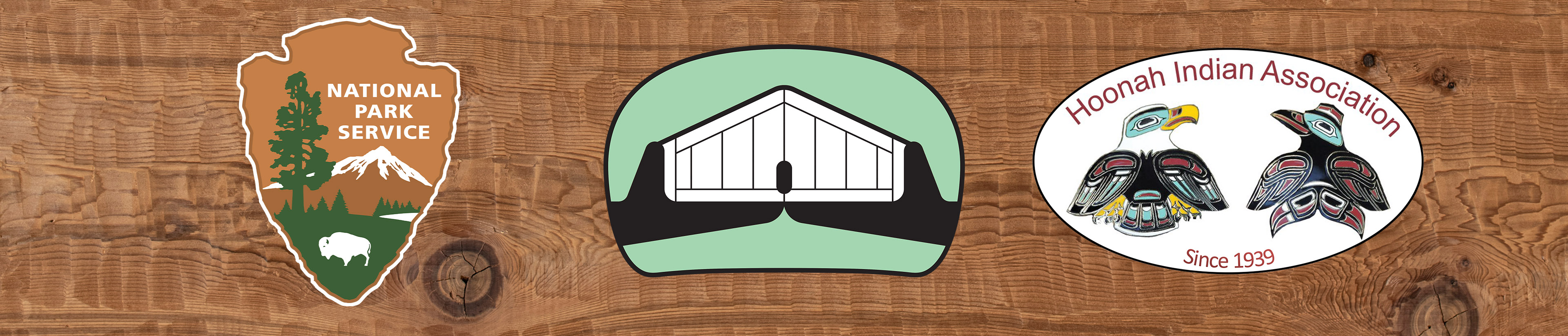 On a backdrop of adzed cedar wood, the logos of the Hoonah Indian Association, Huna Tribal House, and National Park Service are overlaid.