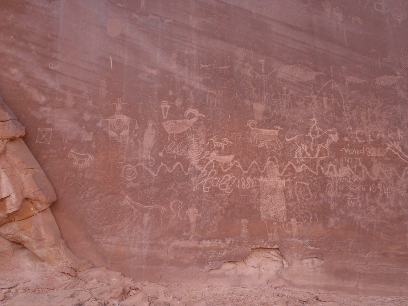 ancient figures and shapes scratched into sandstone wall