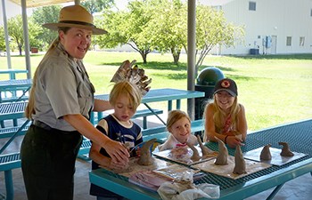 Ranger helps kids with art project at a picnic table