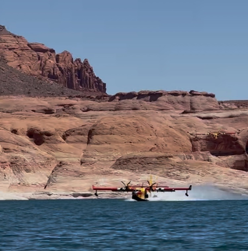Airplance flying very close to the surface of a desert lake.