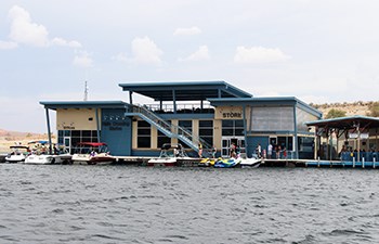 Boats docked outside floating building labeled Store with pavilion on top