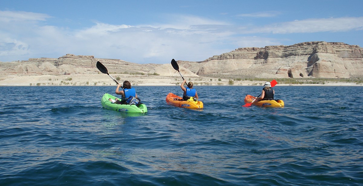 Group of three kayakers paddle on Lake Powell