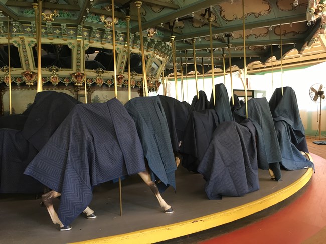 The carousel animals are covered with black tarps.