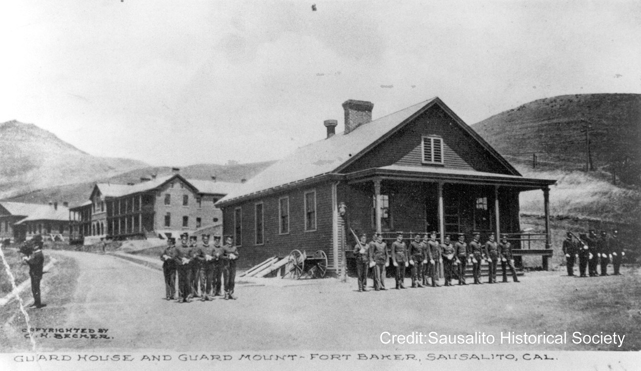 soldiers standing at attention in front of brick building