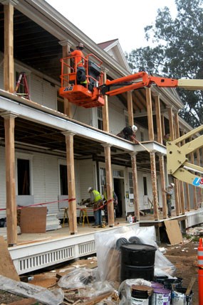 contractors installing wooden veneer on to wooden posts