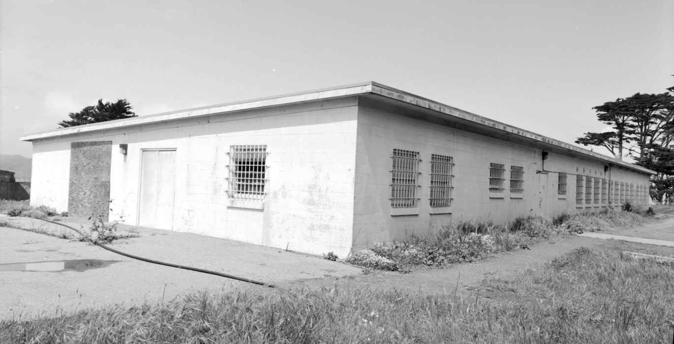 a long white one-story building with bars over the windows