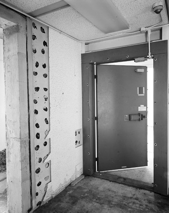 a unoccupied room with a metal door and door frame