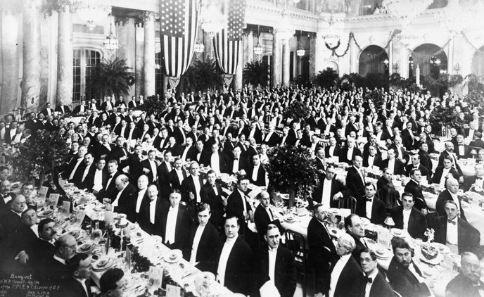 large group of formally dressed men in banquet hall
