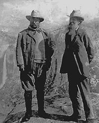 two men wearing hats standing at top of mountain