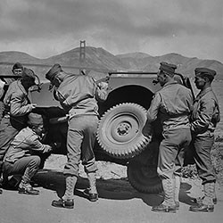 military men replace a tire