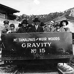 People sit in metal car on track entitled "Mt. Tam and Muir Woods Gravity No.15"