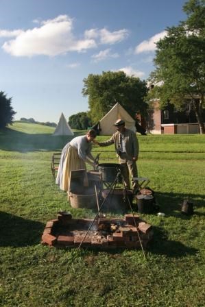 Civil War era living historians prepare a meal in camp.