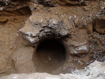 A brick-lined air-shaft that was encountered during construction at Fort Jay.  The shaft leads to an underground vault that was nearly forgotten by time.  As construction continues, dirt fills the vault, slowing construction efforts and posing preservation questions.