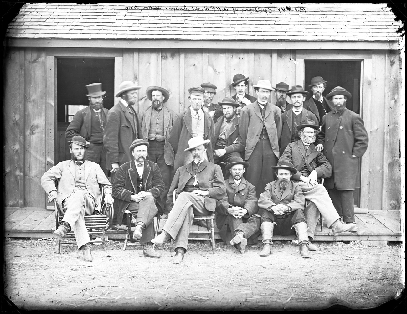 Irish Immigrant railroad workers sitting in front of a railroad station.