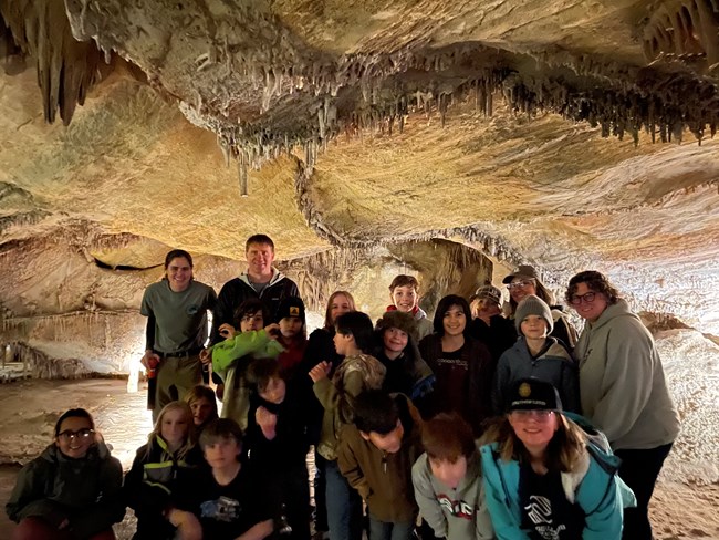 A group of kids stands inside a cave