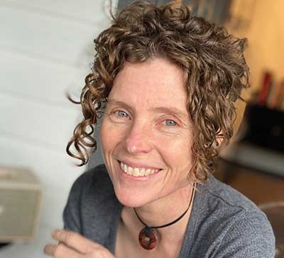 portrait of a smiling woman with curly brown hair