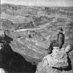 Man sitting on rock looking at canyon