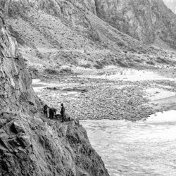 Men on cliff edge with river below