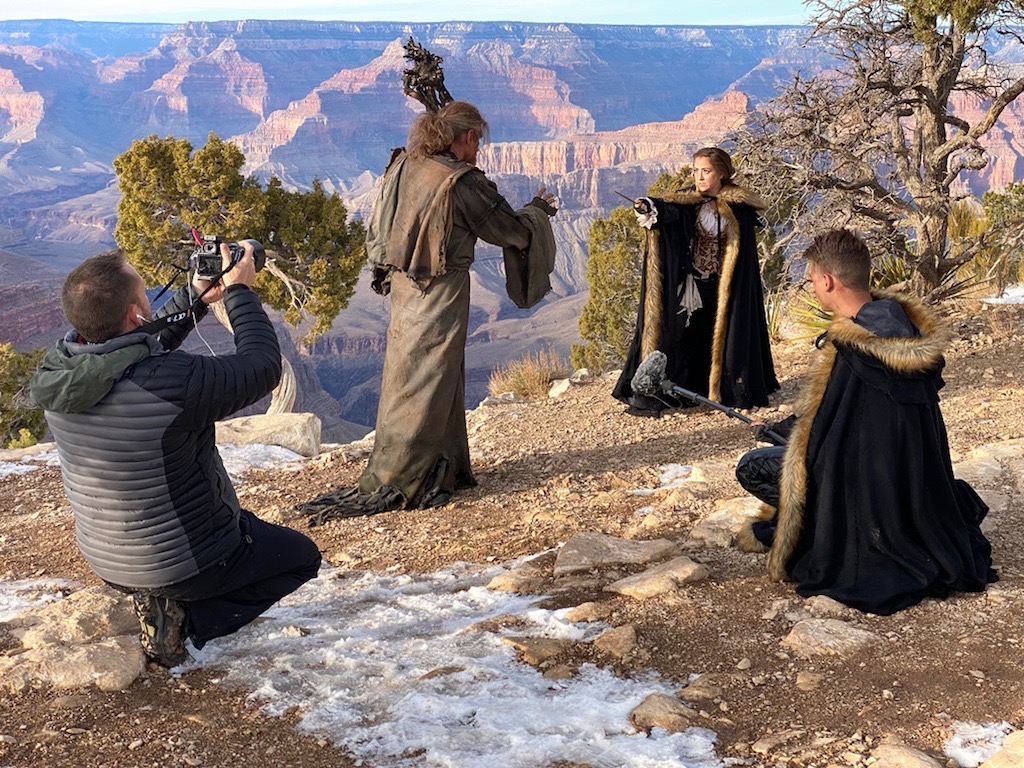 A lady wizard casts a magic spell while filming on the rim of Grand Canyon