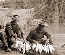 15774 - 2 MEN WITH A STRING OF HUMPBACK CHUB FISH & COLLAPSIBLE BOAT. COLORADO RIVER NEAR PHANTOM RANCH. CIRCA 1911. RUST COLLECTION