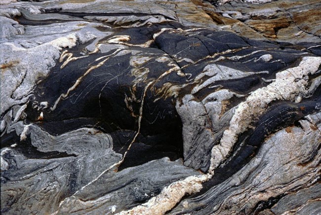 Igneous rock showing waves of gray and black.