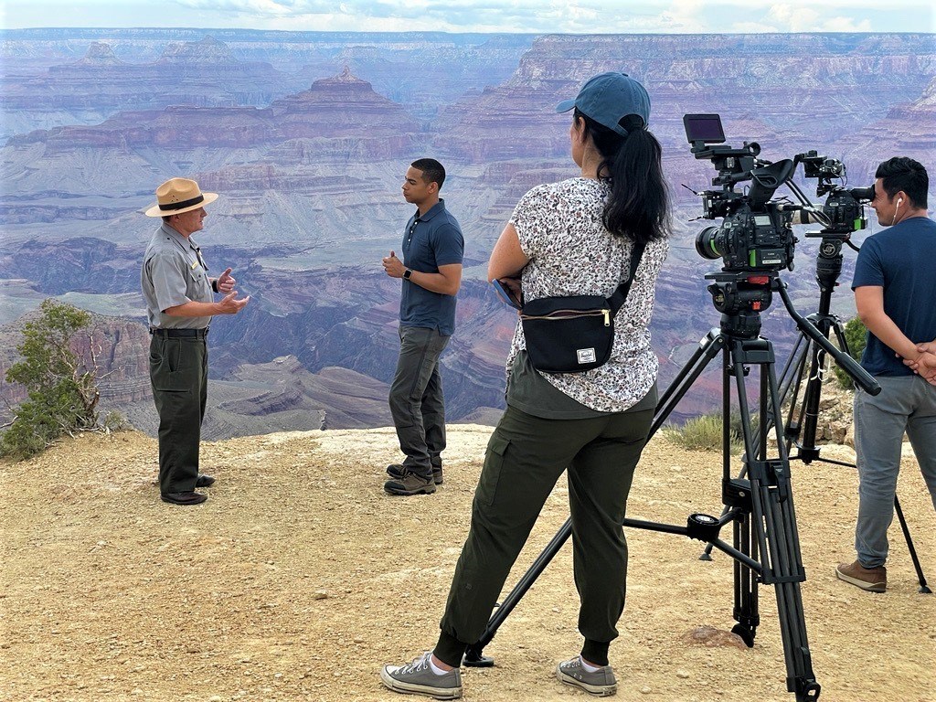A news crew interviews the park superintendent at the edge of the canyon