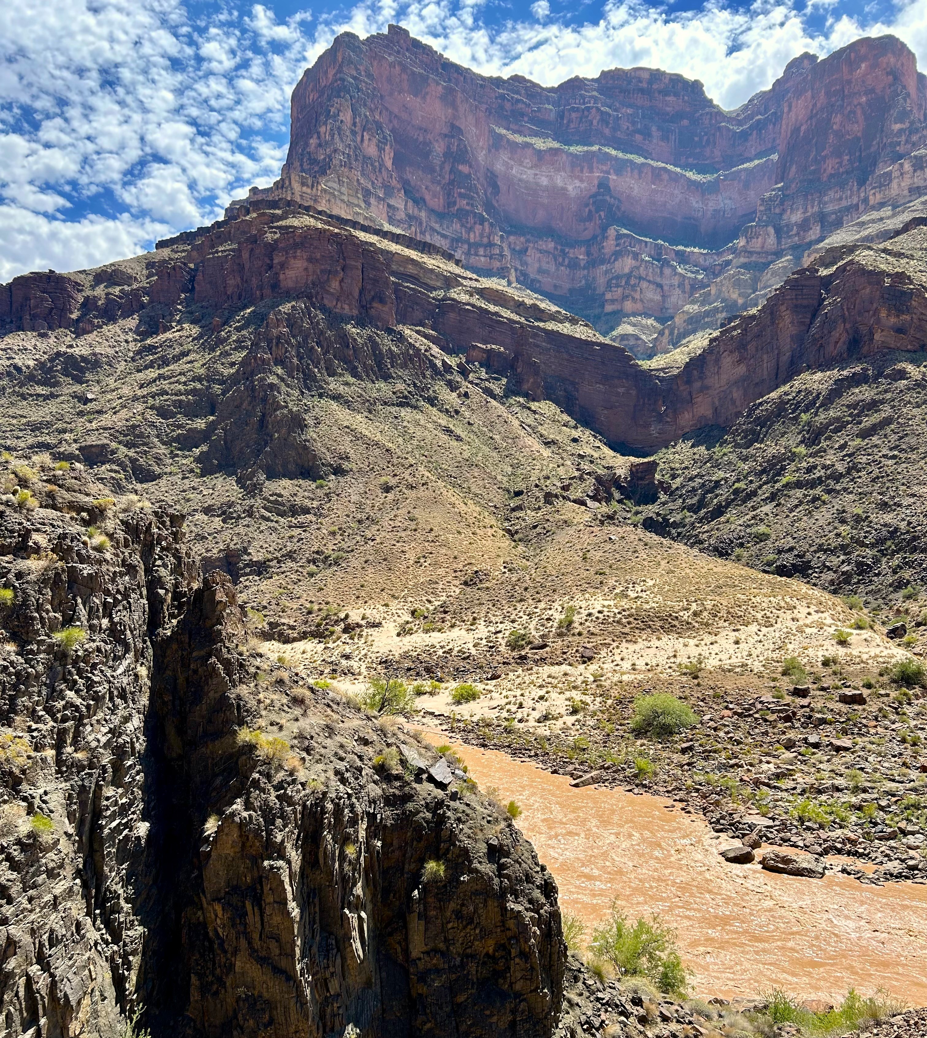 The Colorado River is seen in stark contrast with a steep canyon landscape